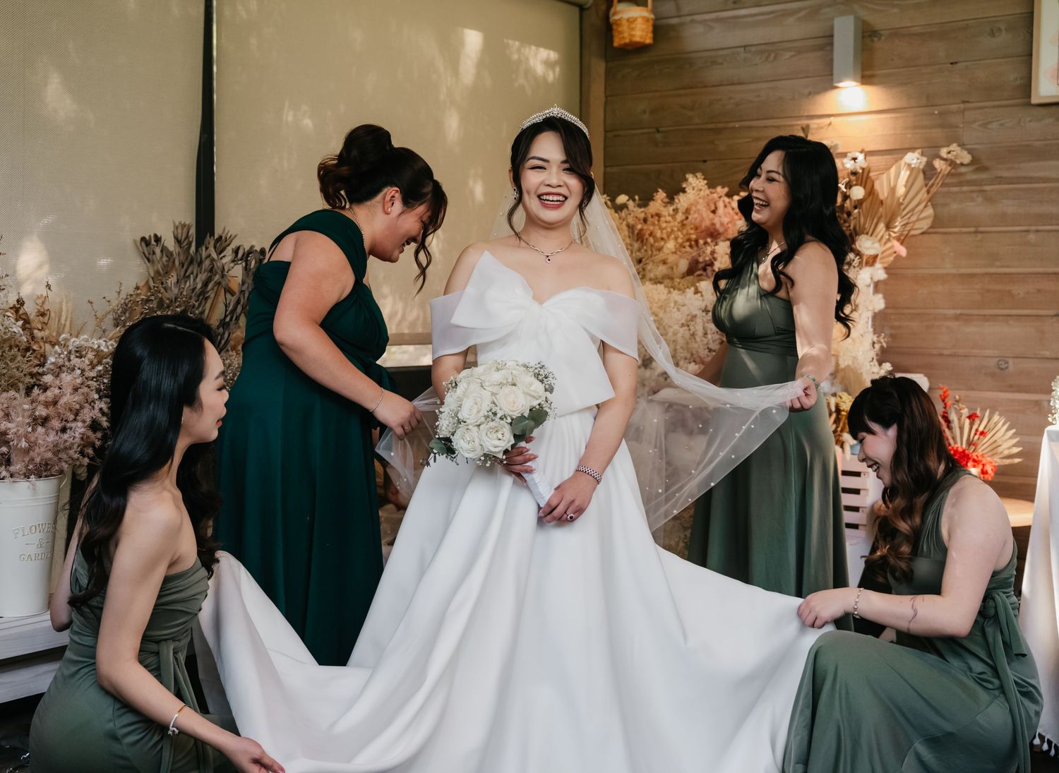 Collage of wedding party members in dark green dresses helping adjust a flowing white wedding gown.