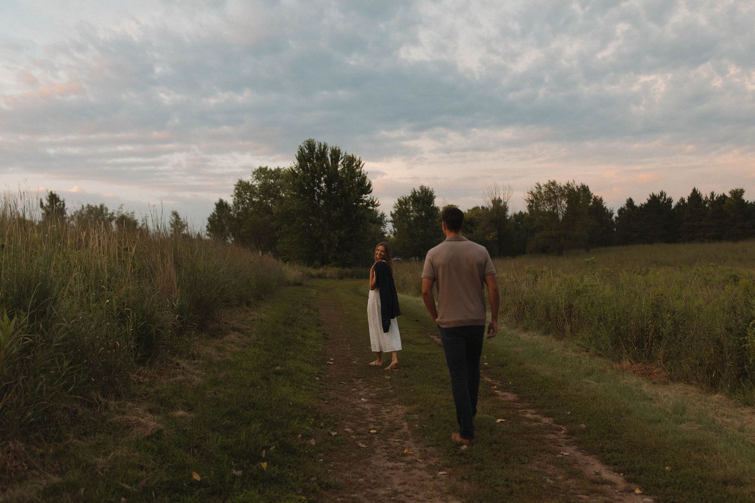 Group walking along a scenic countryside path at sunset.