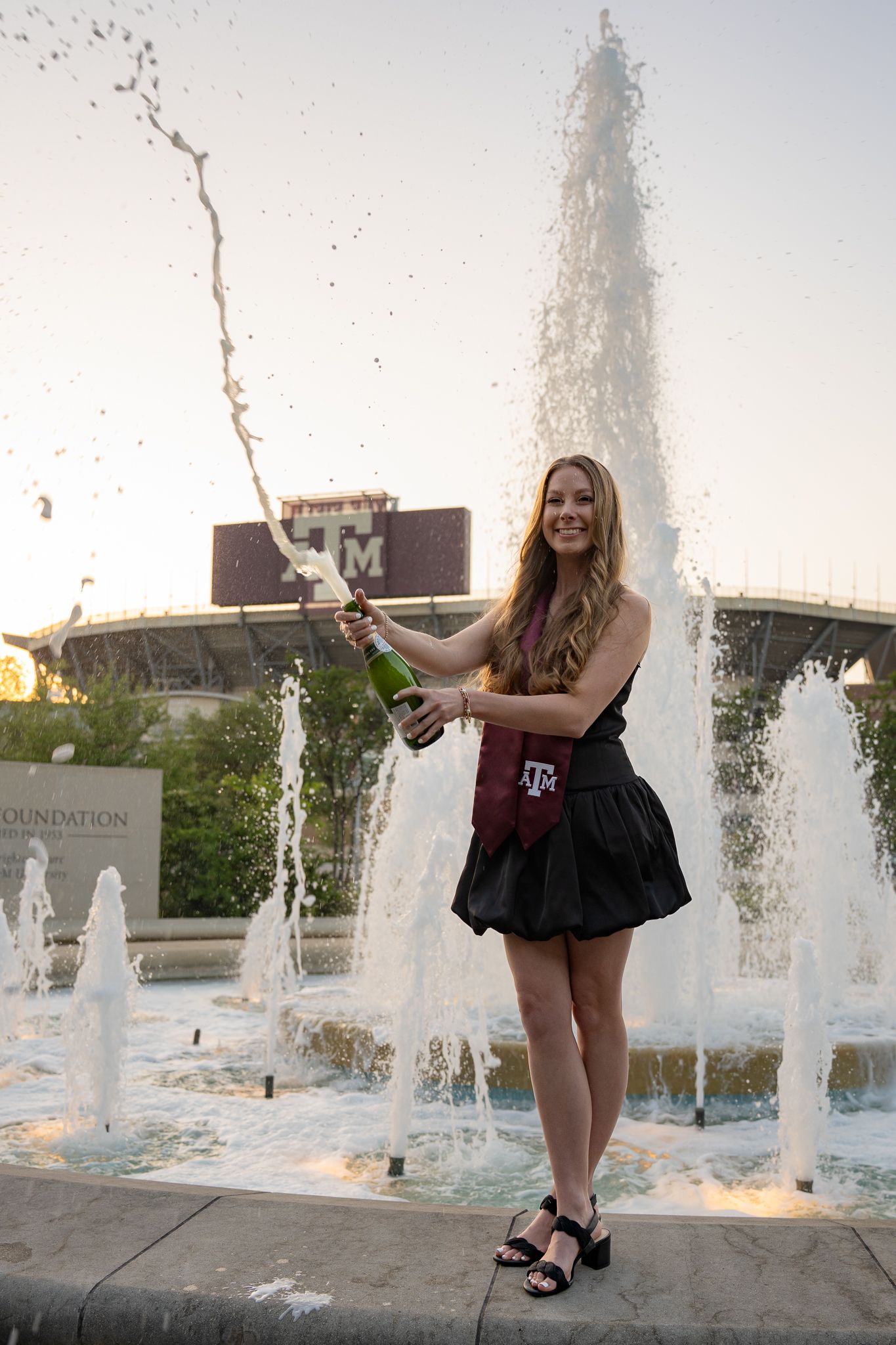 A series of photos showing someone posing playfully near outdoor water fountains at sunset.