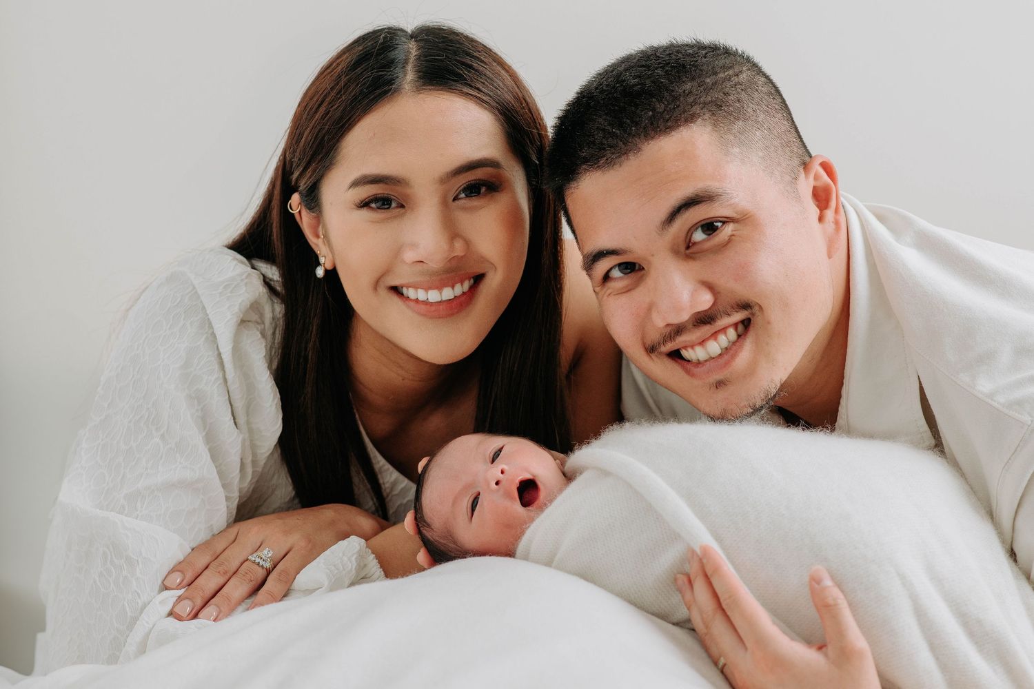 A series of intimate family photos showing tender moments between parents and their newborn baby on a white background.