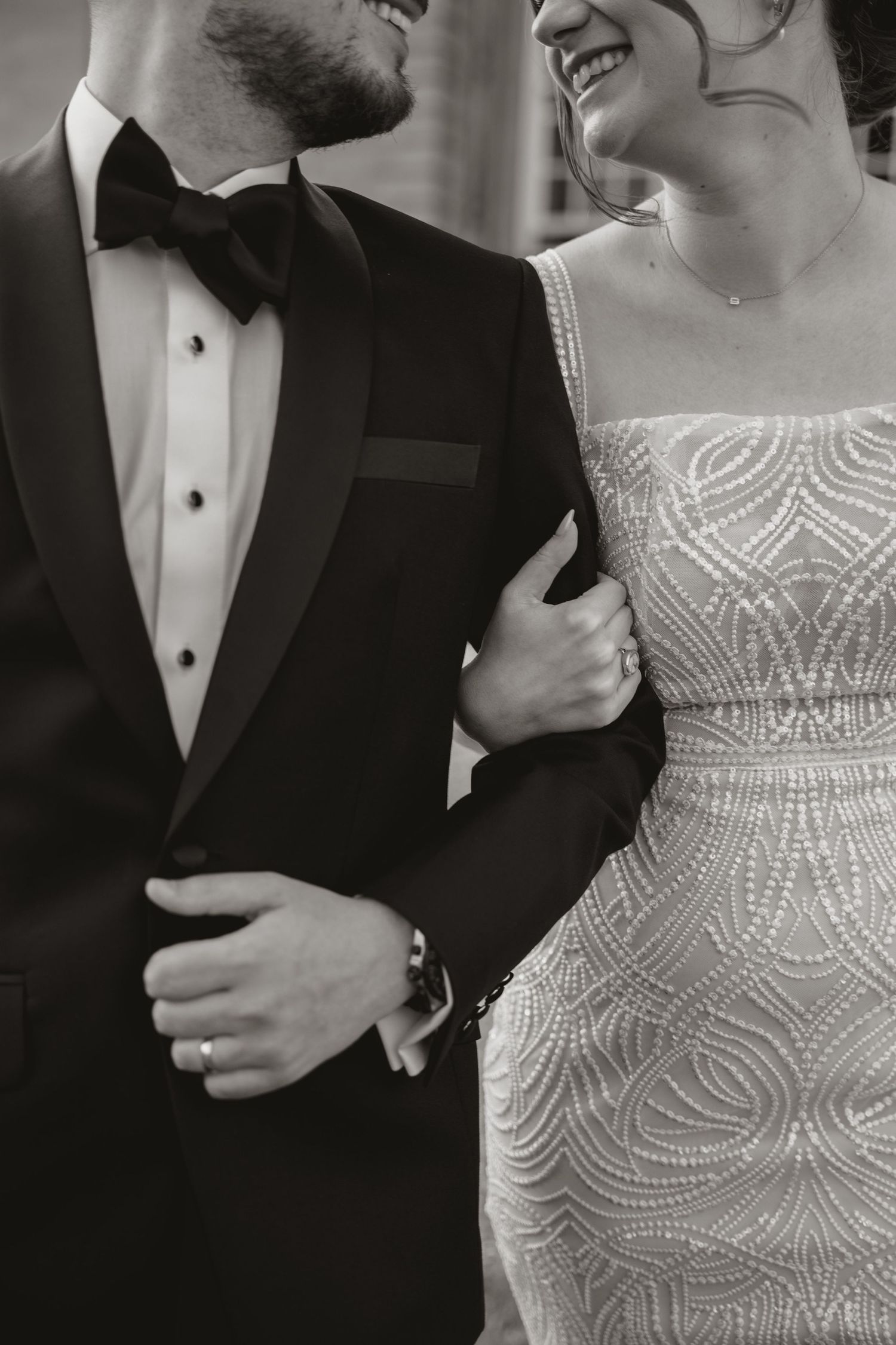 A black and white elegant wedding photo showcasing wedding attire in a luxurious dining room with ornate decor.