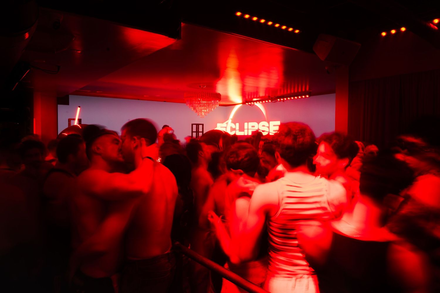 A group of blurred partygoers under red lighting in motion at a nightlife event in Chicago