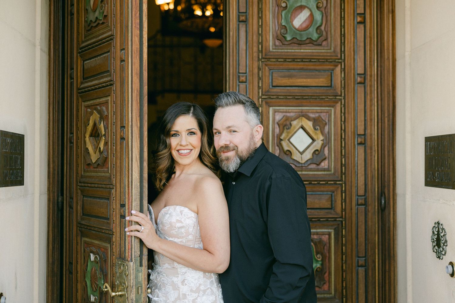 Couple posing in front of wood carved doors