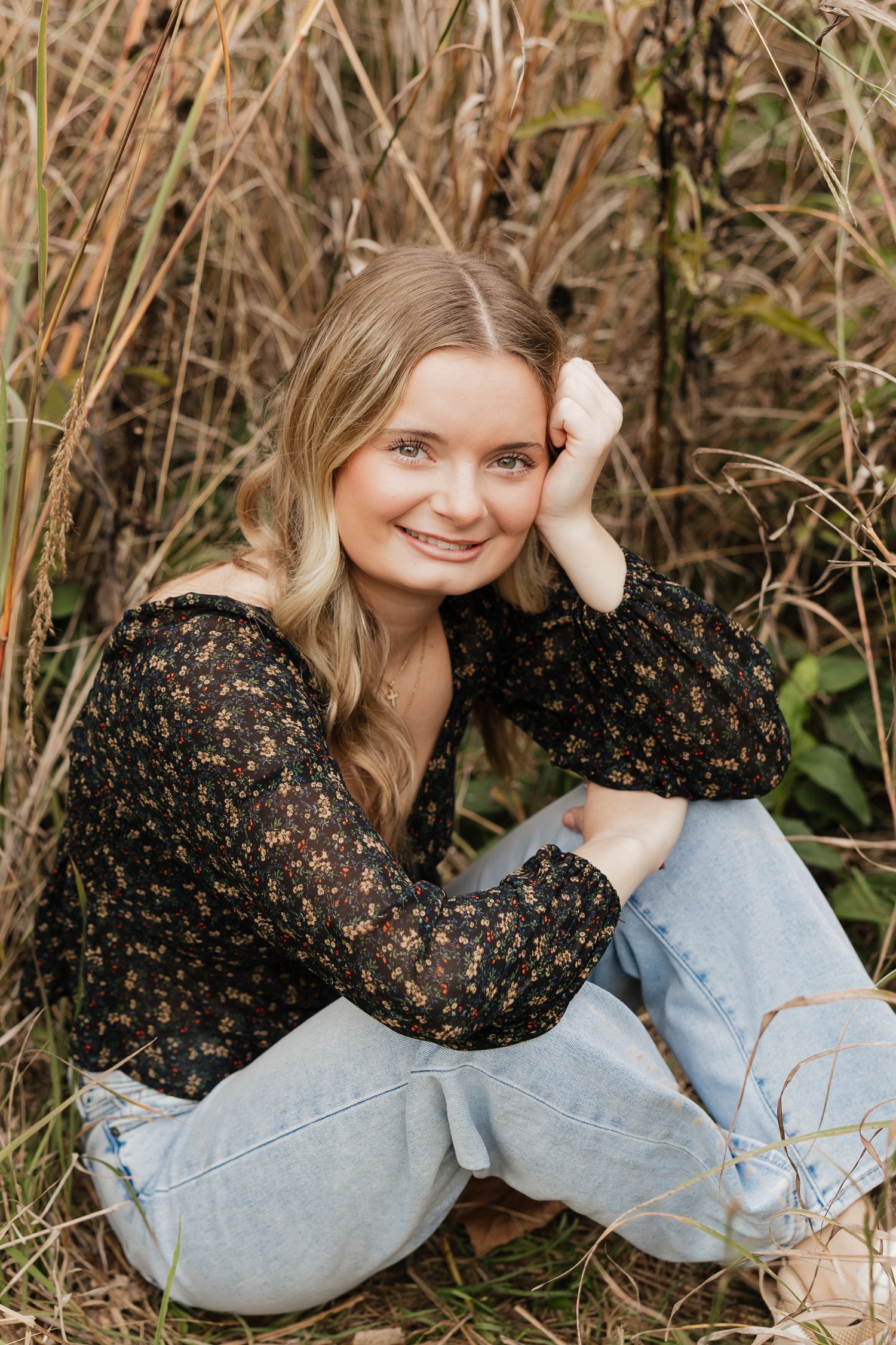 A series of outdoor portrait shots showing someone lying in tall grass wearing a floral top and light denim.