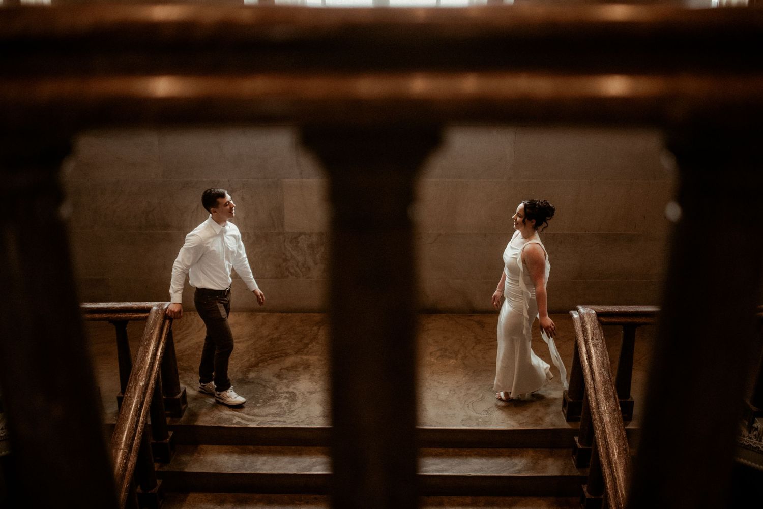 Engagement couple in Nashville, TN as they walk towards each other during their photo session while framed inside the building stairwell.