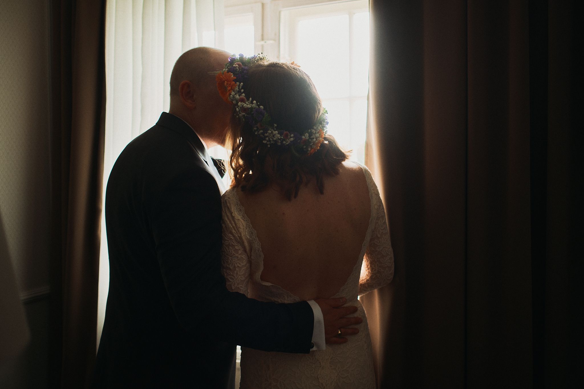 A silhouetted couple shares a romantic kiss in front of a dramatic sunset sky.