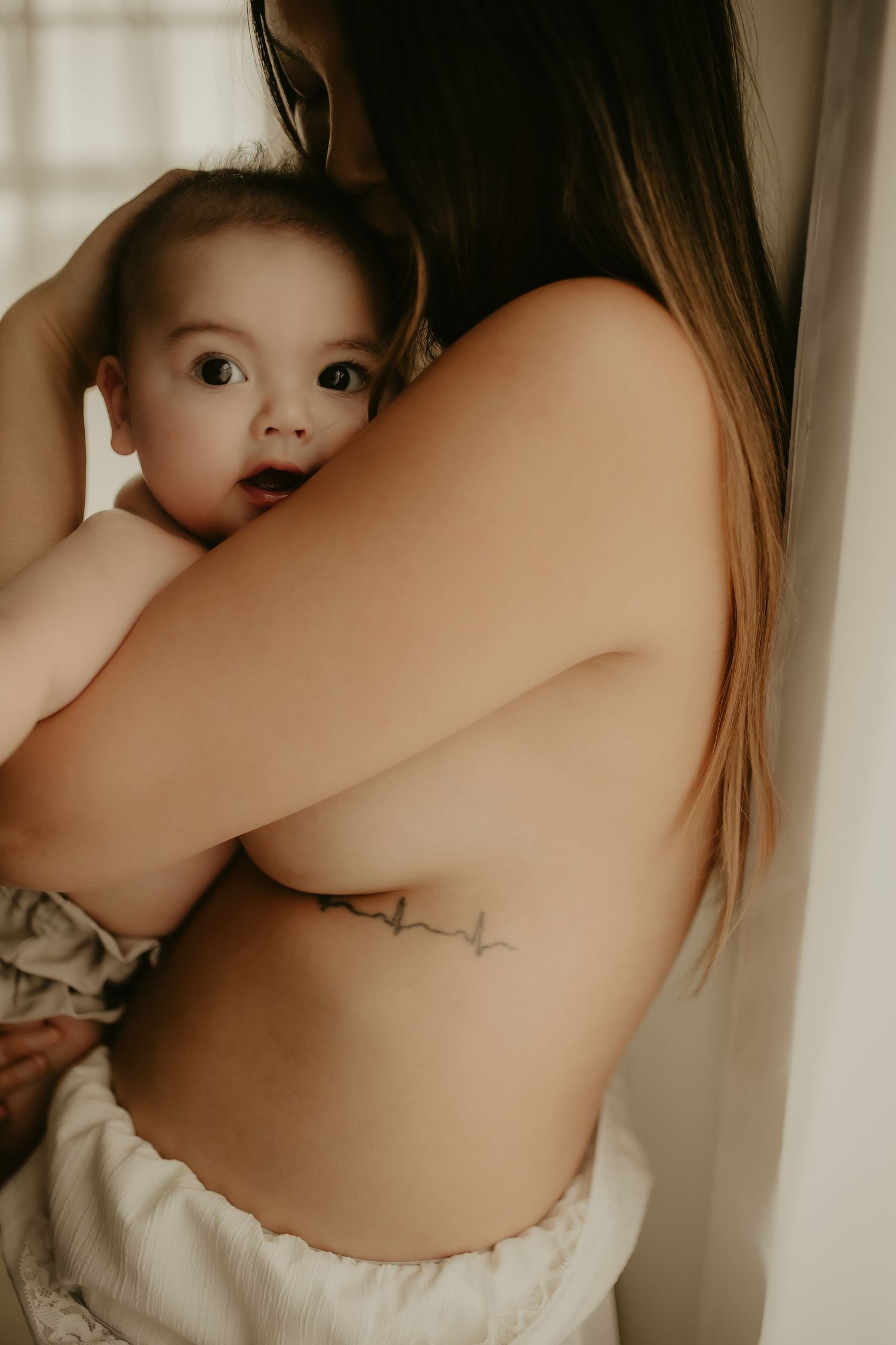 A series of intimate maternity photos showing a brown knit sweater against white fabric in warm, sepia-toned lighting.