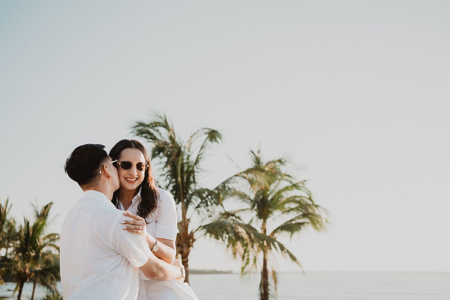 Sesión de pareja en Mazatlán entre palmeras y vista al mar.