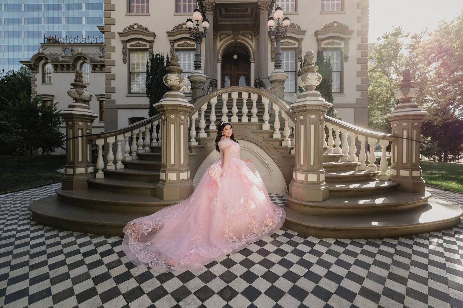 Quinceanera in red ballgown quince dress with floral details and crown poses in a church for quince ceremony.