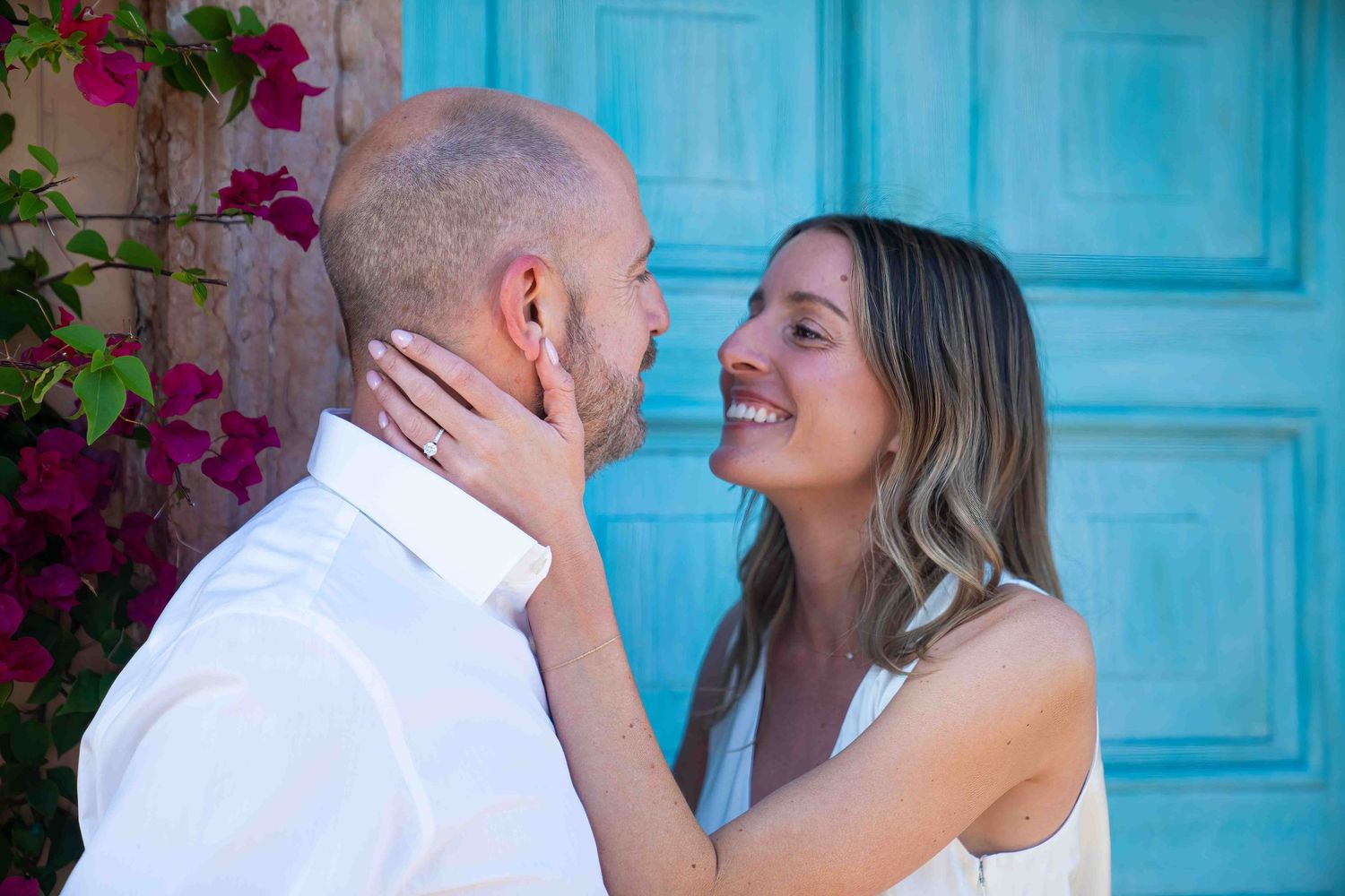 Kari and Jeff looking at eachother lovingly in front of a beautiful Mediterranean-style door on Worth Avenue.