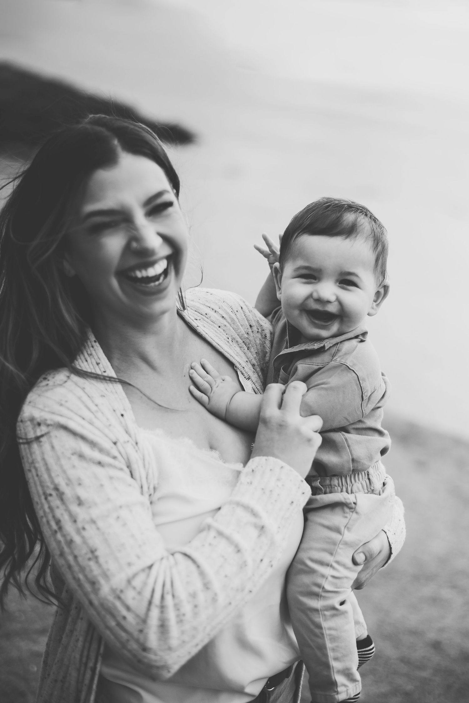 A joyful black and white portrait of pure happiness shared between mother and baby outdoors at Whitty's Lagoon in Metchosin, BC.