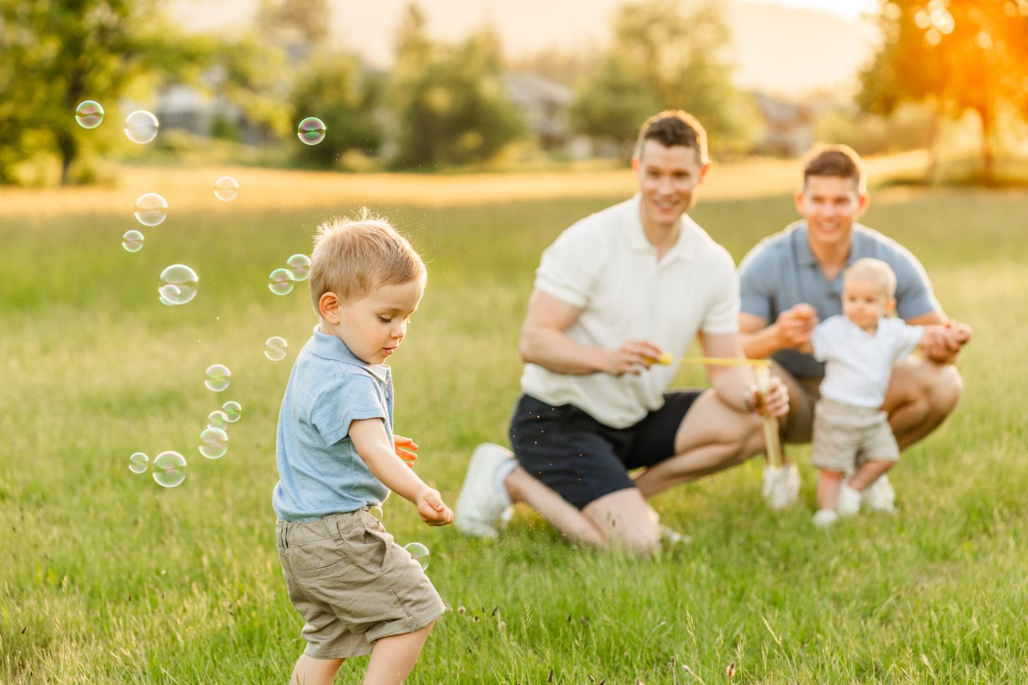 Family blowing bubbles in a field at sunset in North Bend.