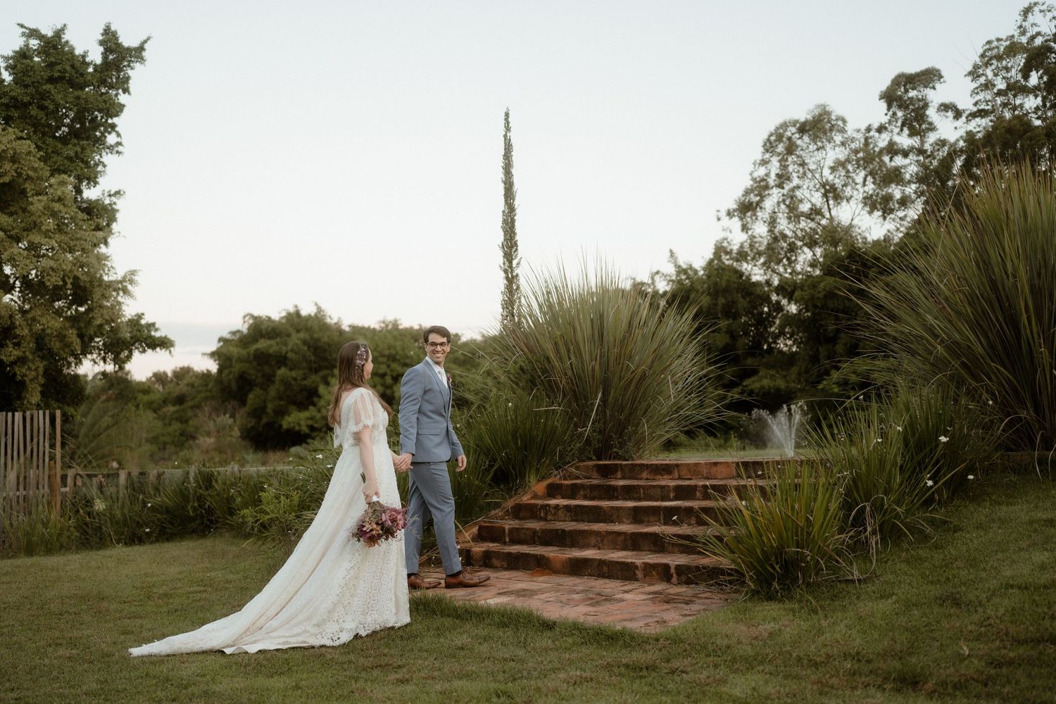 Scenic outdoor wedding ceremony setup with a long pathway leading to stone steps.