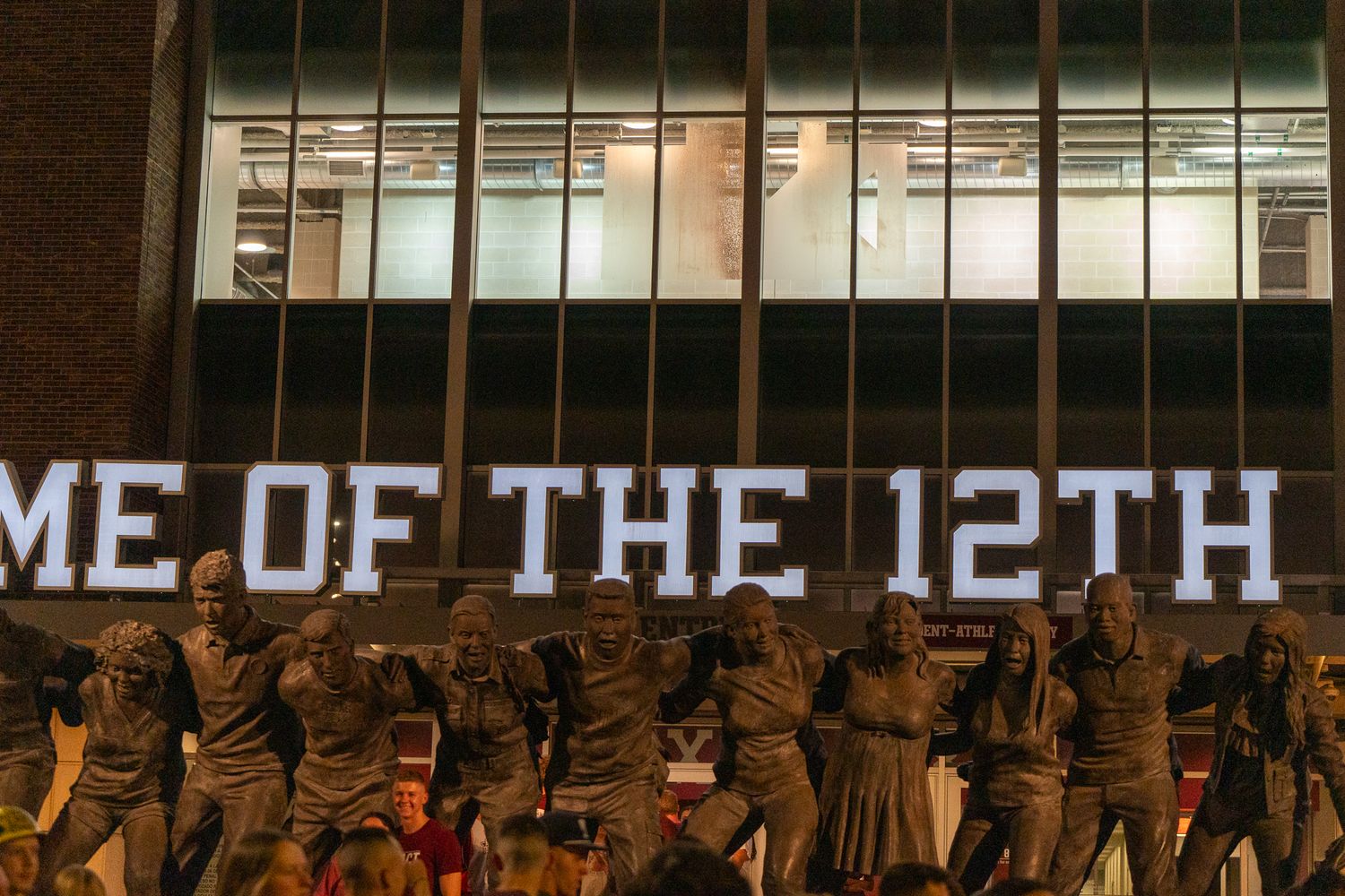 Illuminated 'Home of the 12th' text display with statues silhouetted below.