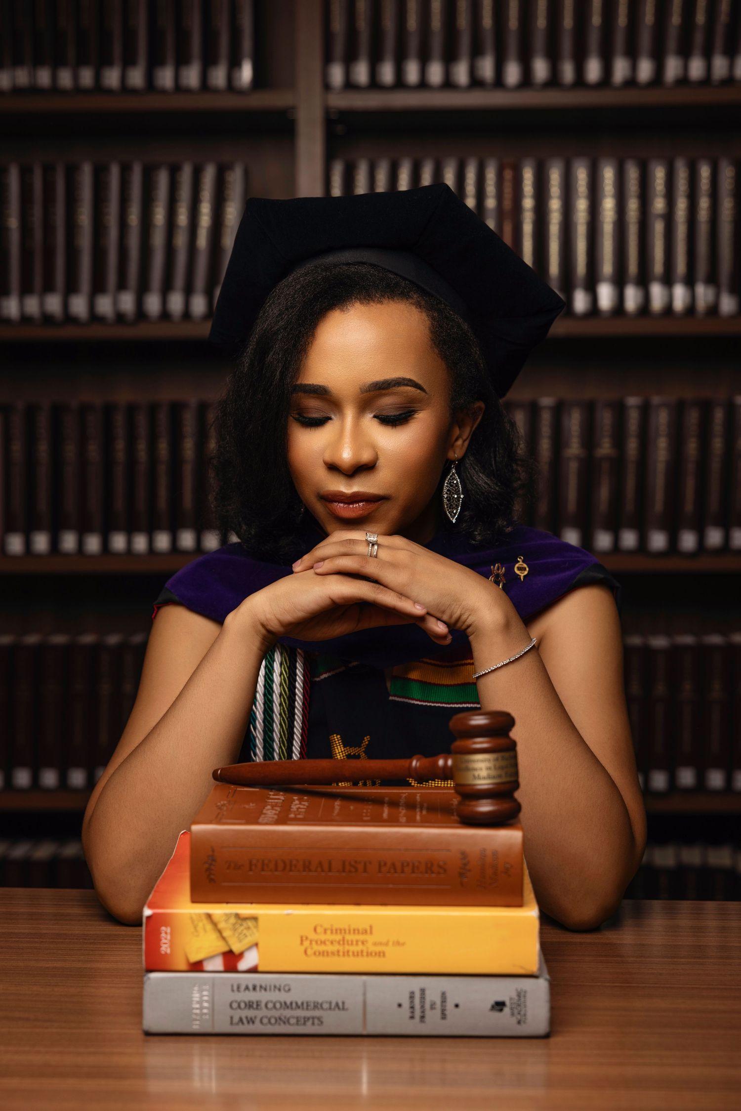 Law-themed portrait with legal books and gavel on wooden desk in library setting.