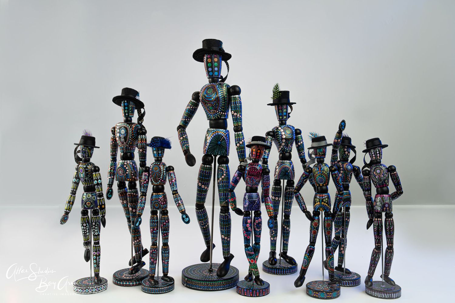 Collection of metal wire sculptures depicting stylized figures wearing hats.