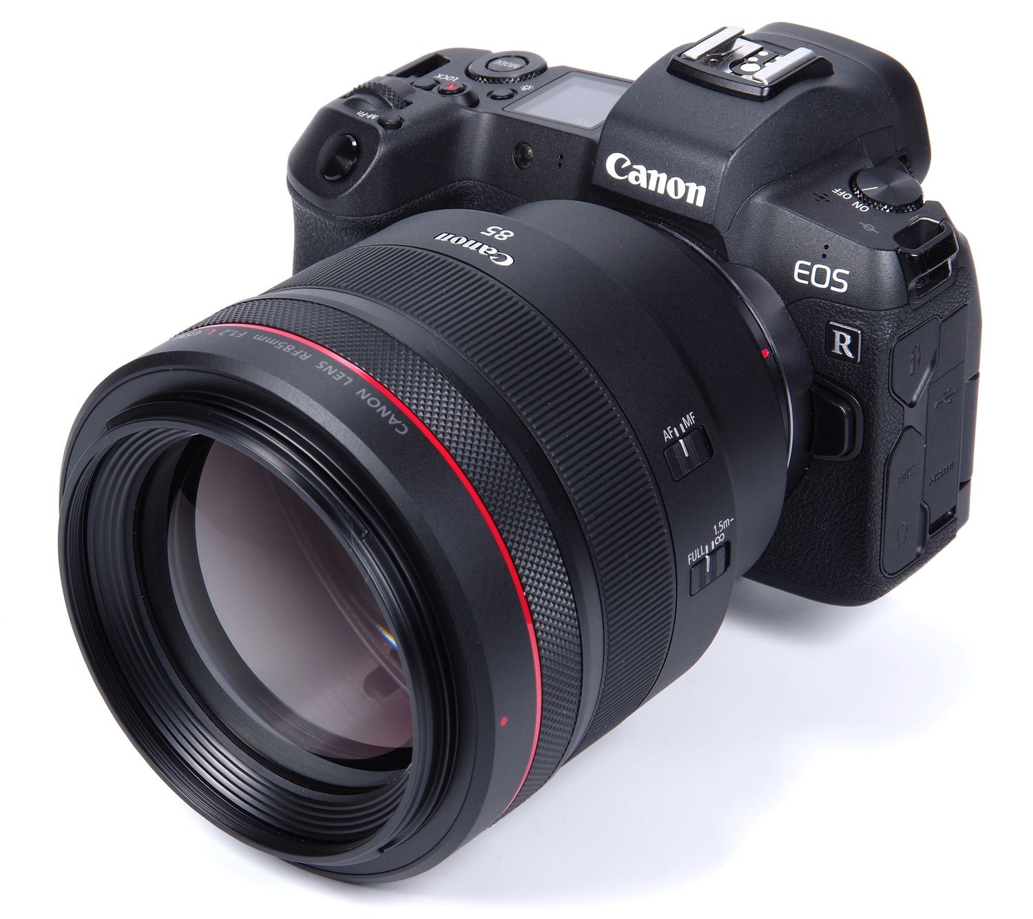Close-up view of Canon professional lens showing red ring detail and metallic mount against blurred background.