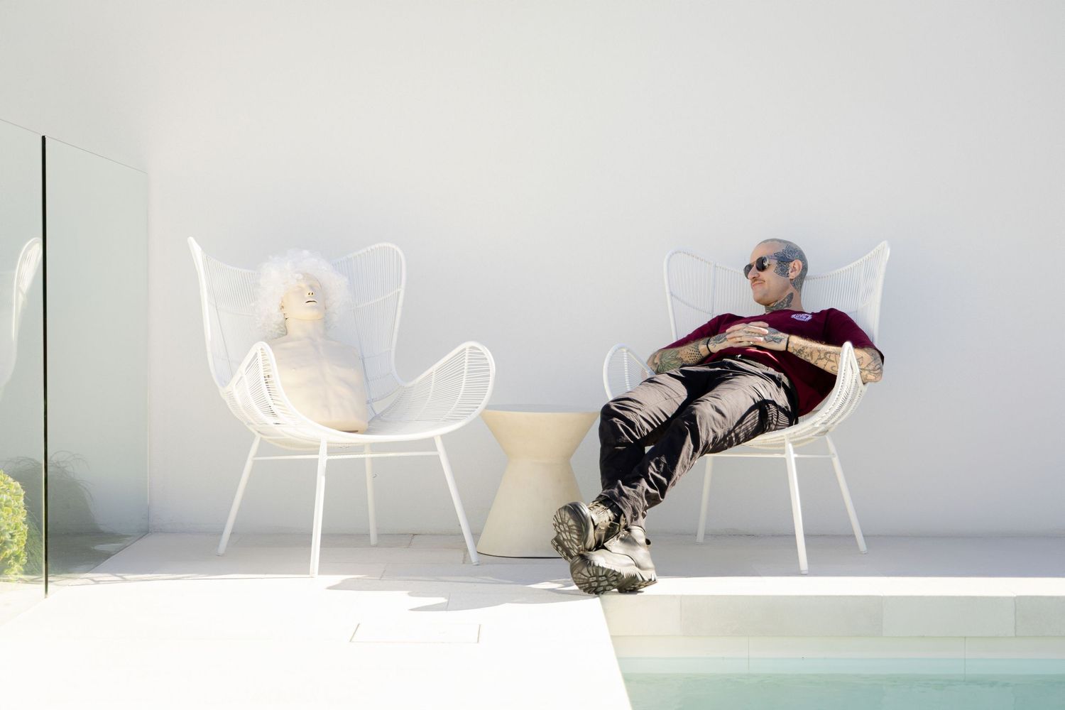 Contemporary white chairs arranged minimally in a bright interior with a gray background.