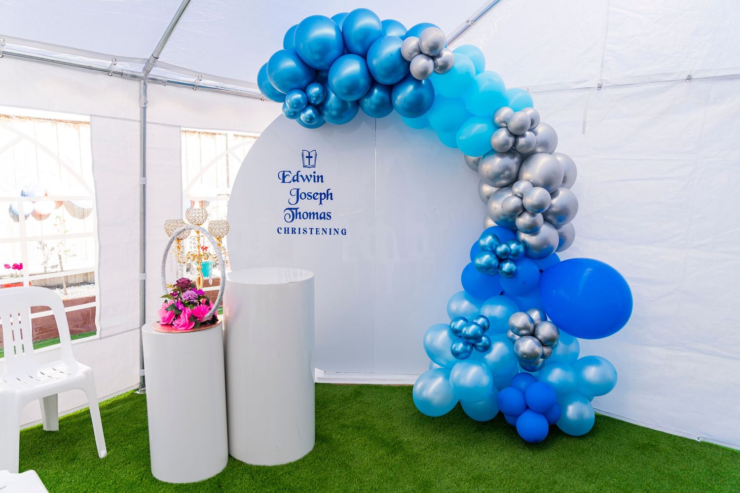 Elegant balloon arch decorations in blue and silver colors create a festive atmosphere at an outdoor event setup.