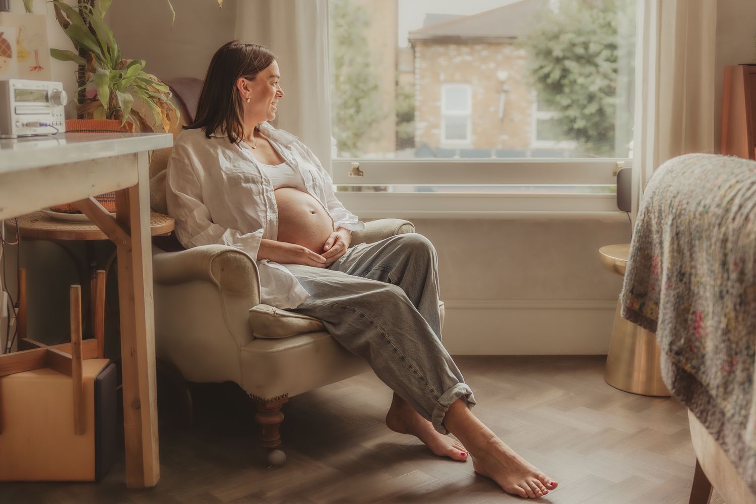 A bright, sunlit nursery room with natural light streaming through large windows.