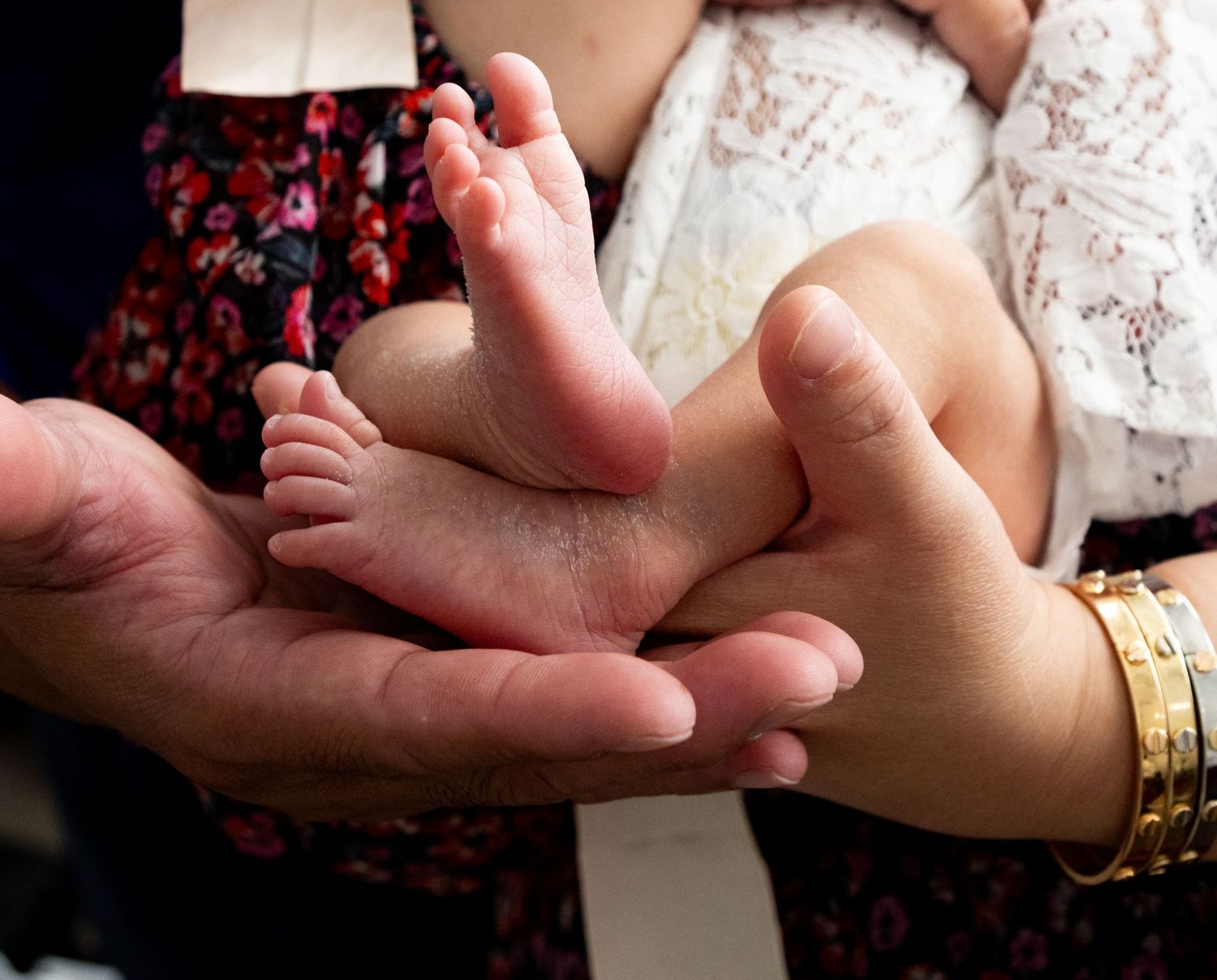 Artistic close-up of baby feet against a dark background with soft lighting.