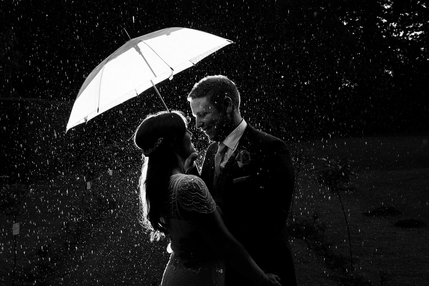 bride and groom under umbrella in rain on wedding day in Nova Scotia