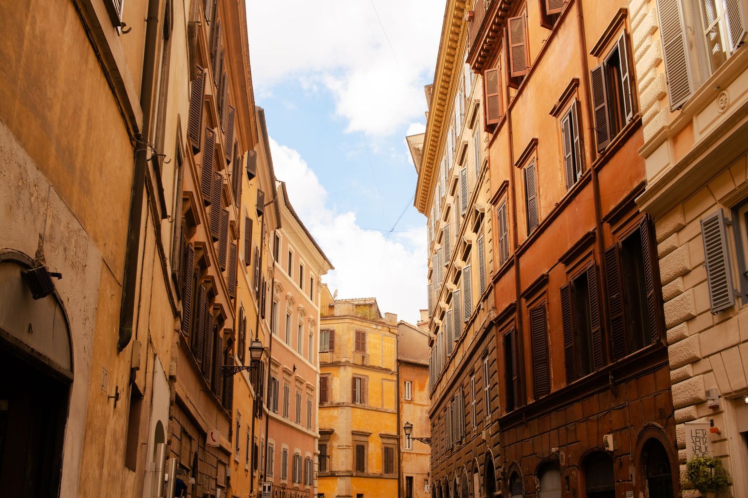 A street in Rome with beautiful, warm toned buildings.