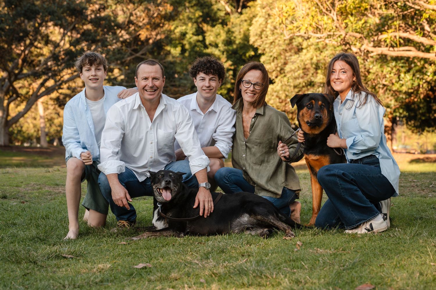 5 membered family with their 2 large dogs smiling during their family photoshoot