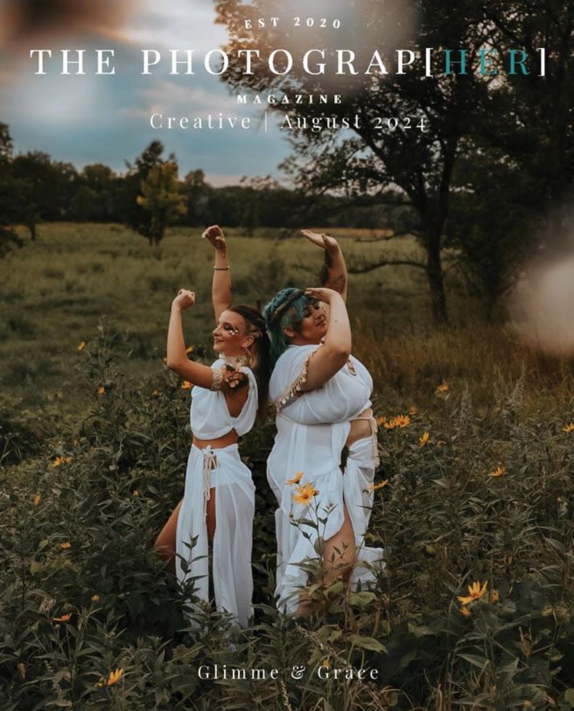 Two figures in flowing white dresses dance joyfully in a golden field at sunset with wildflowers blooming around them.