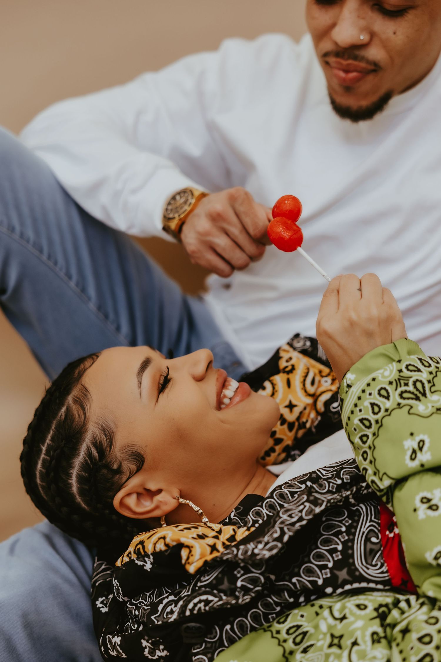 Playful moment captured as person feeds heart-shaped lollipop while lying down.