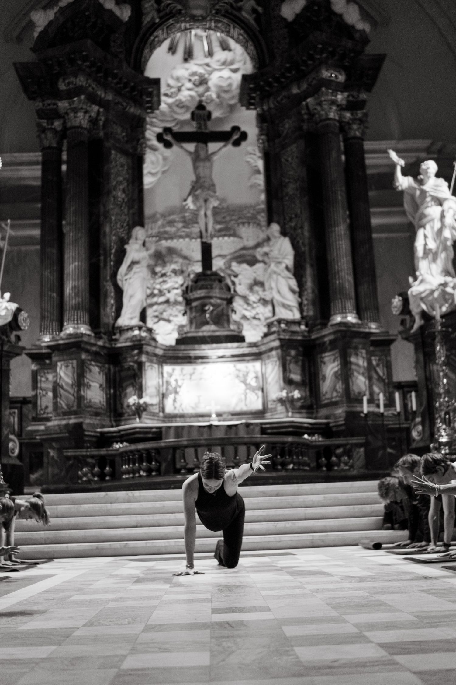 a yoga teacher standing in a yoga pose with extended hand in a church while being captured by yoga photographer in Stockholm
