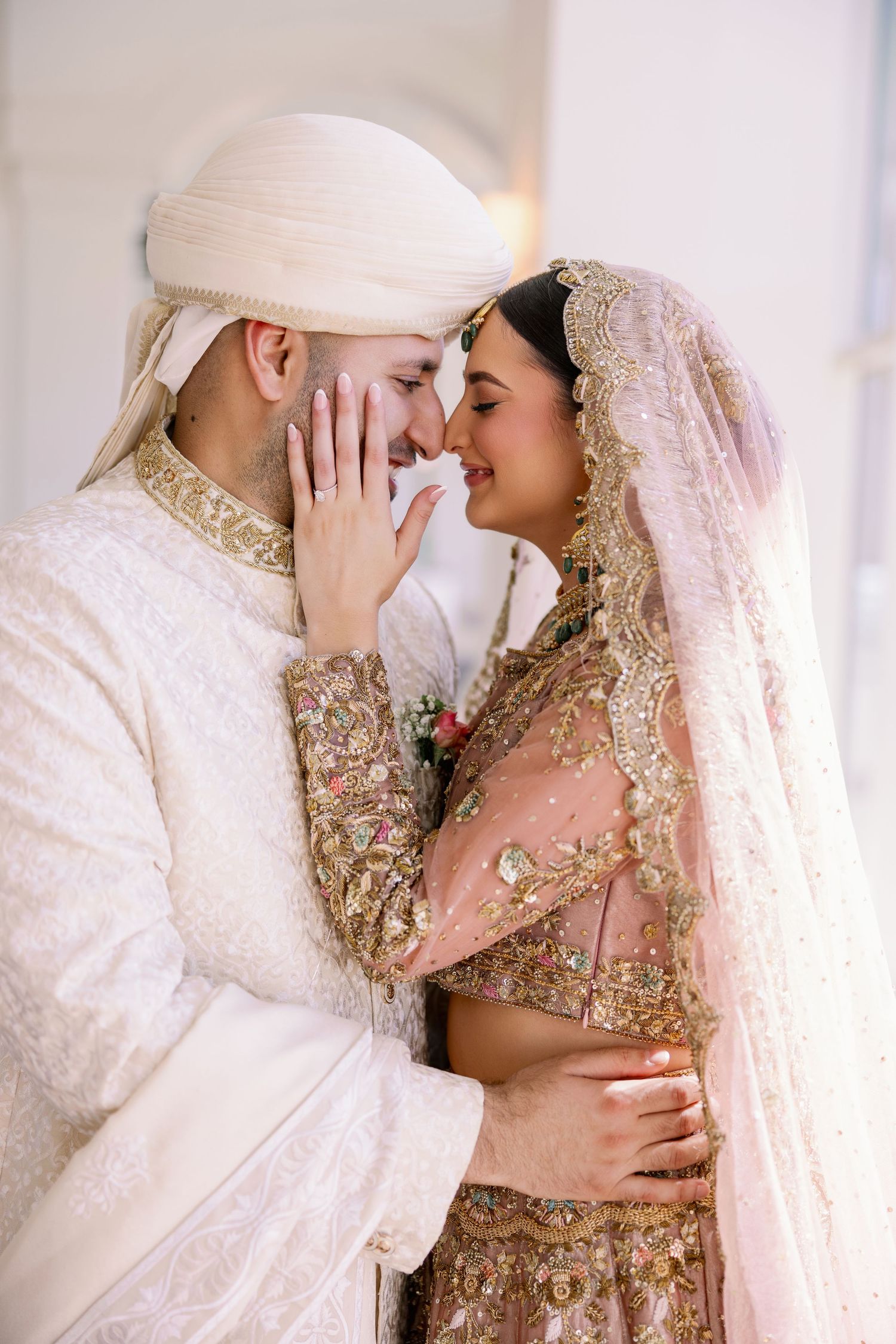 A romantic wedding portrait of a couple sharing an intimate moment in traditional attire.