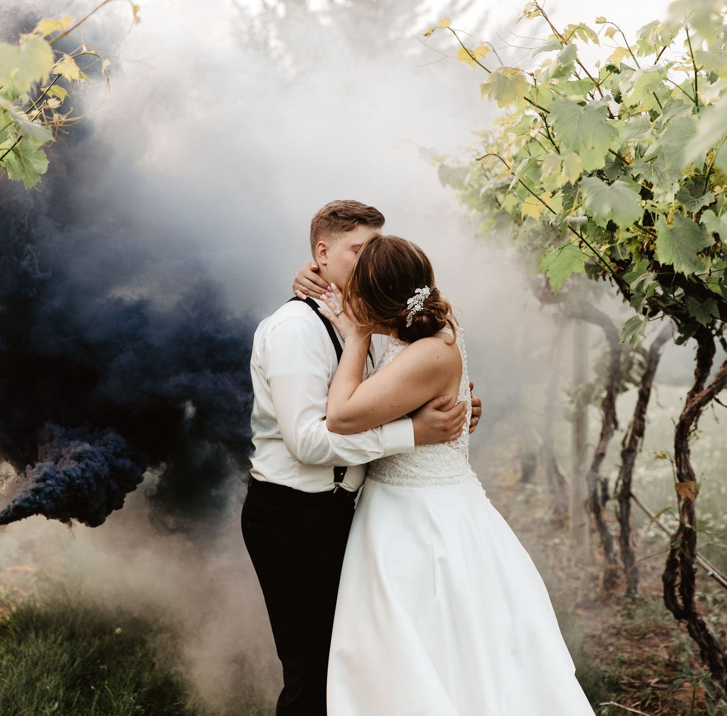 Romantic wedding photo series in a misty vineyard with dramatic smoke effects and atmospheric lighting.