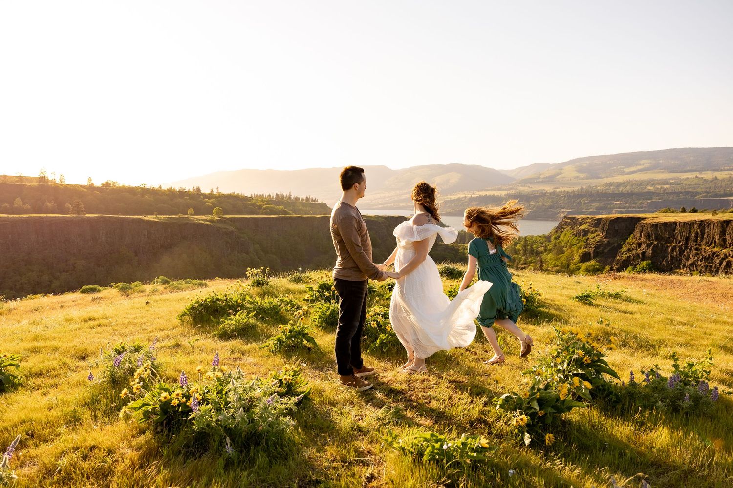 Silhouettes of people enjoying a scenic mountain vista at sunset.