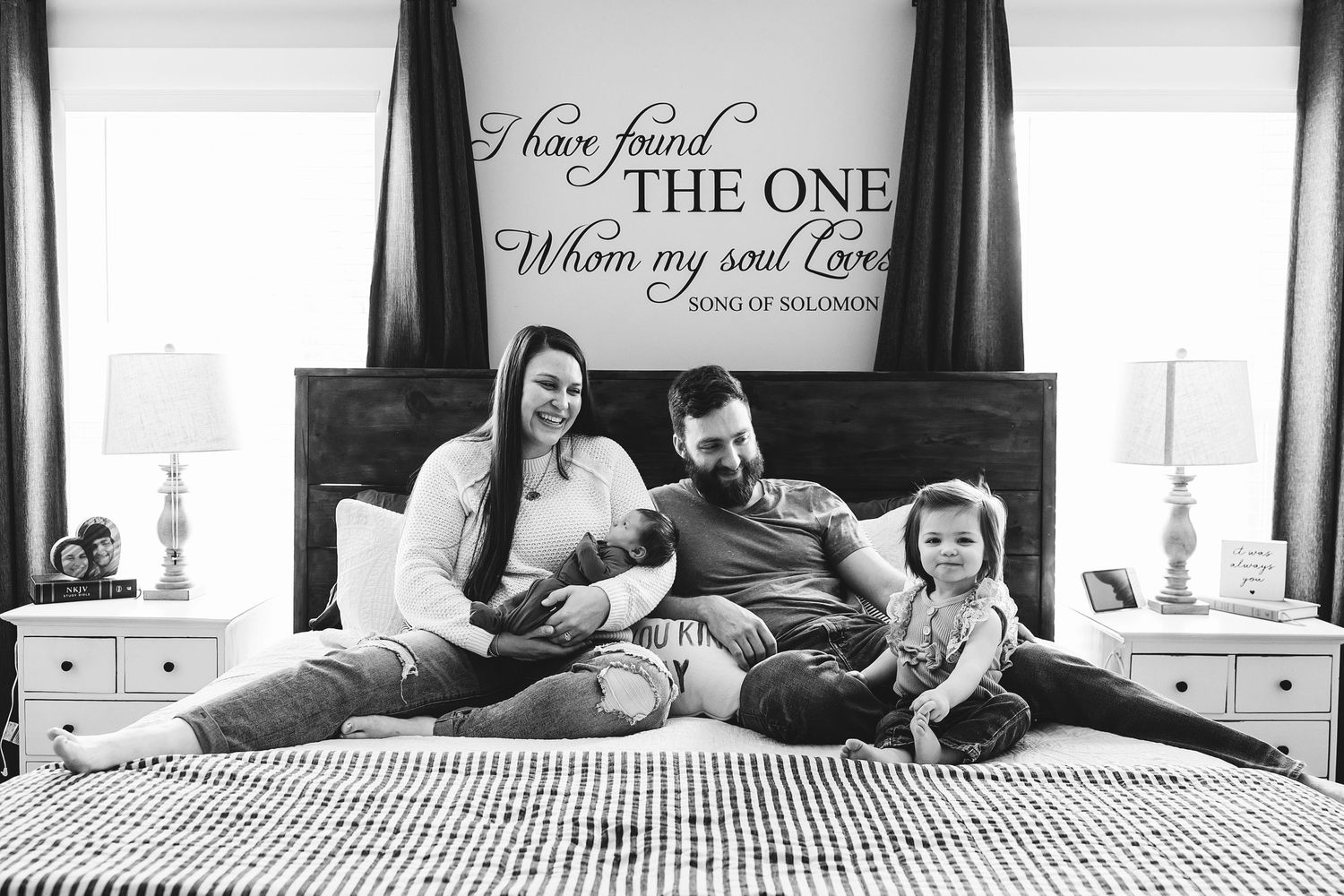 Lifestyle newborn photography session in a family home capturing parents cuddling their newborn in natural window light
