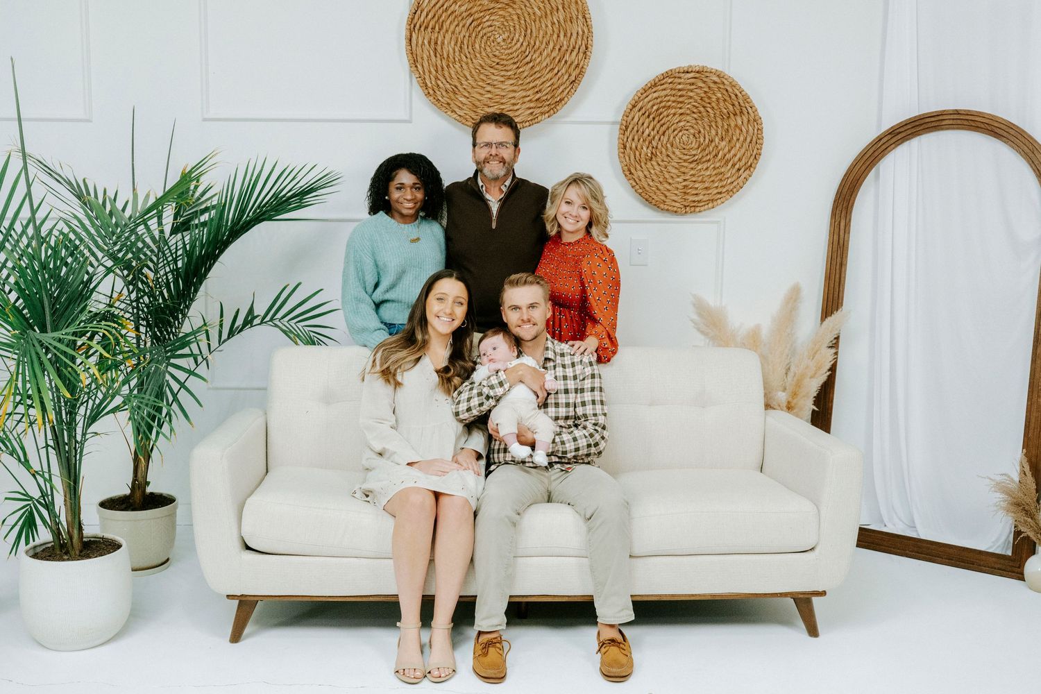 A series of five minimalist white interior photos showing a couch, decorative cork circles, and plants against white walls.