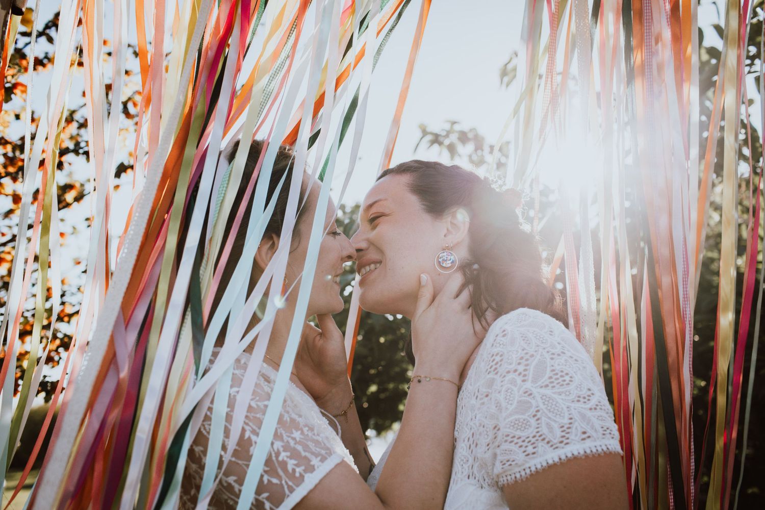 A joyful couple dancing together at an elegant indoor wedding venue with chandeliers visible in black and white.