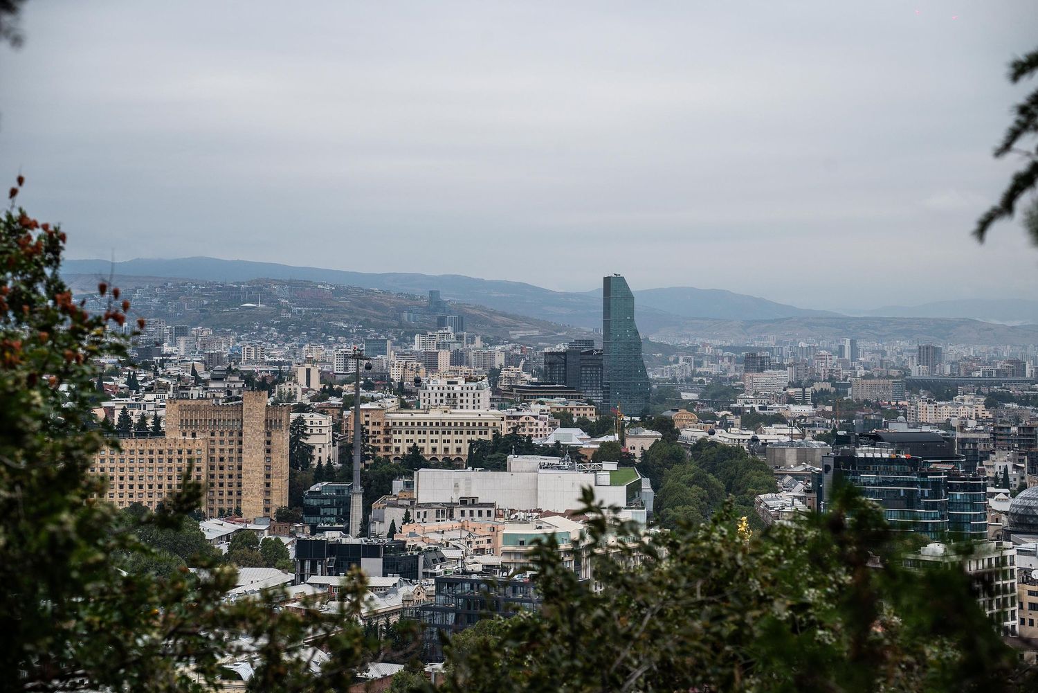 Panoramic view of Portland Oregon skyline with mountains and urban buildings stretching across the horizon.