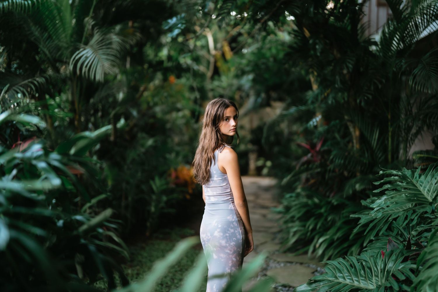Serene swimming pool scene surrounded by tropical greenery and natural lighting.
