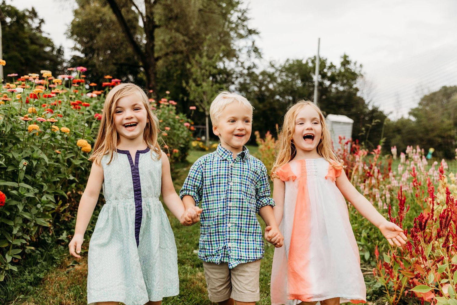 Joyful children playing and laughing together in a garden filled with colorful flowers.