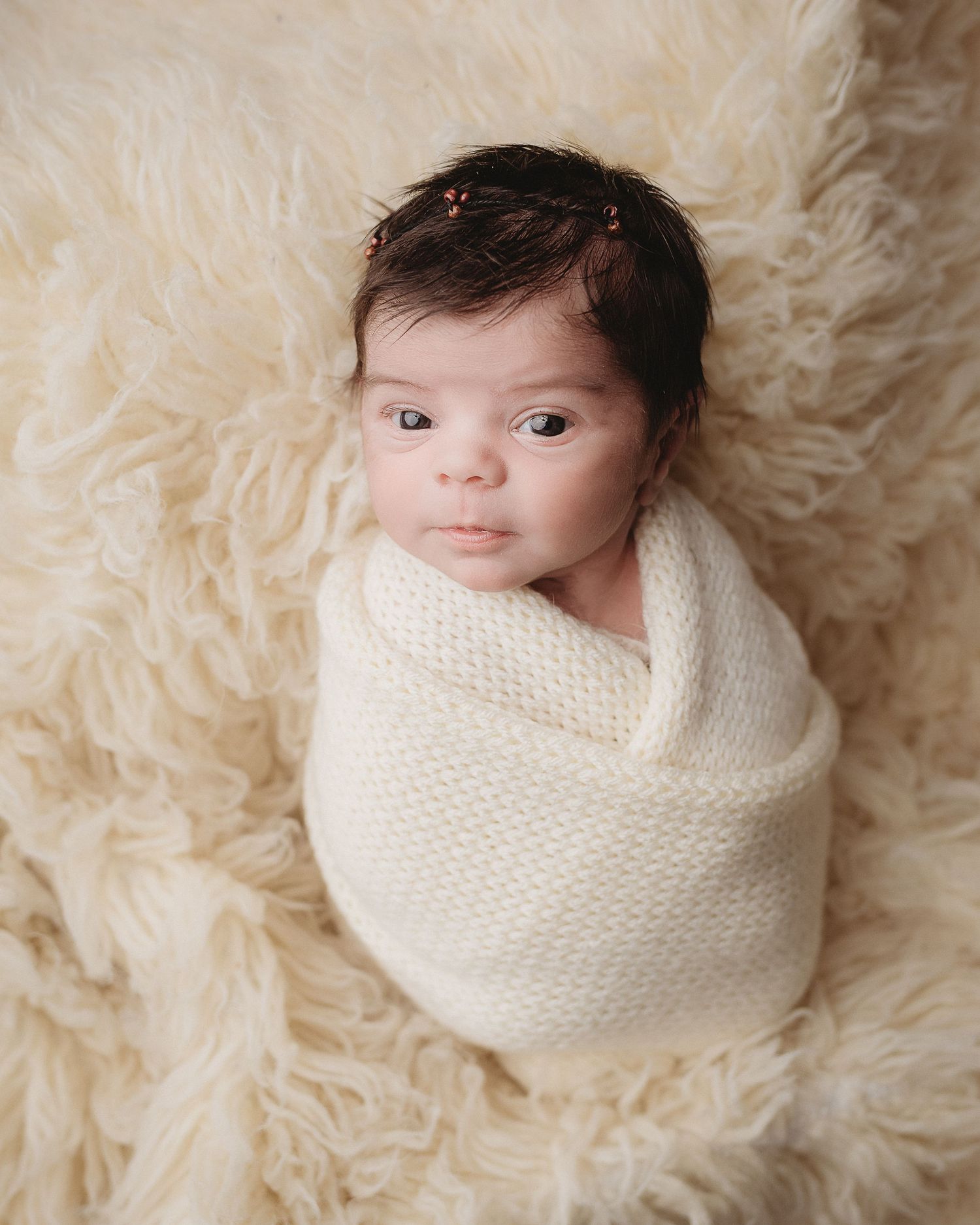 Professional photo of a newborn baby wrapped in white
