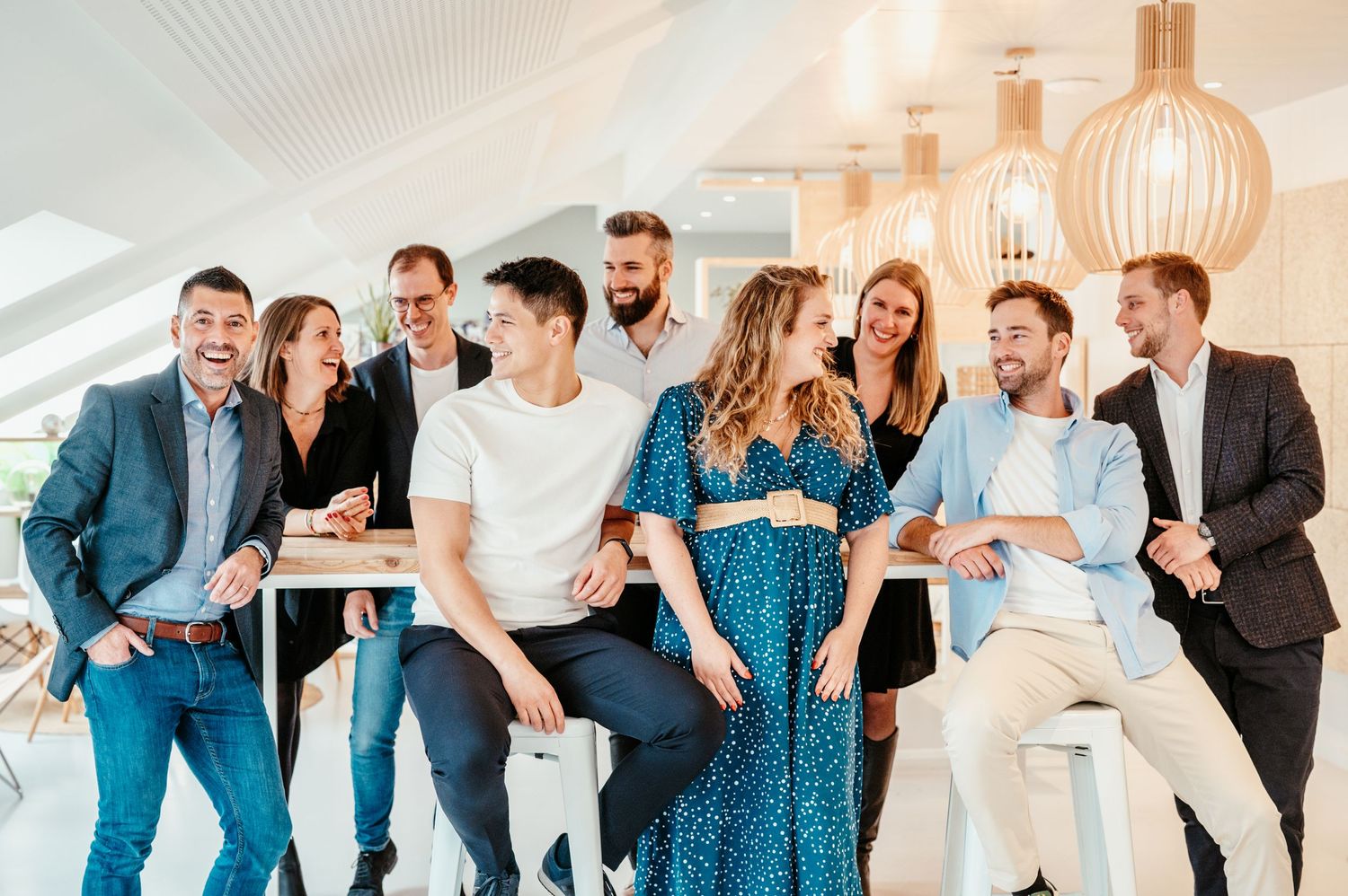 Groupe de collaborateurs souriant en tenue business casual dans un espace moderne, illustrant comment s’habiller pour une photo d’entreprise