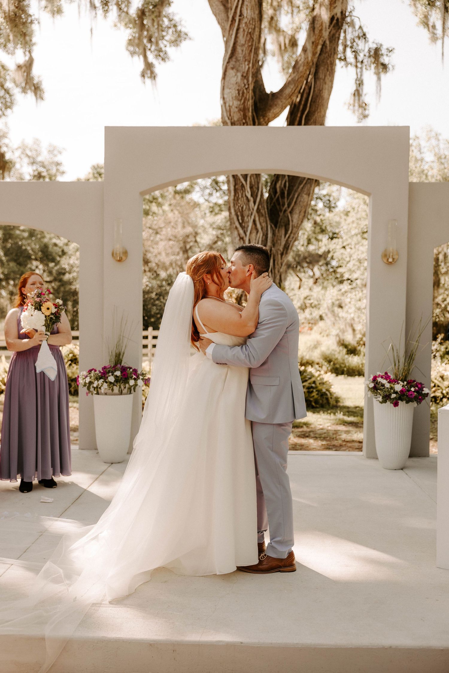 Wedding ceremony photos under a white columned pavilion with romantic lighting and floral decorations.