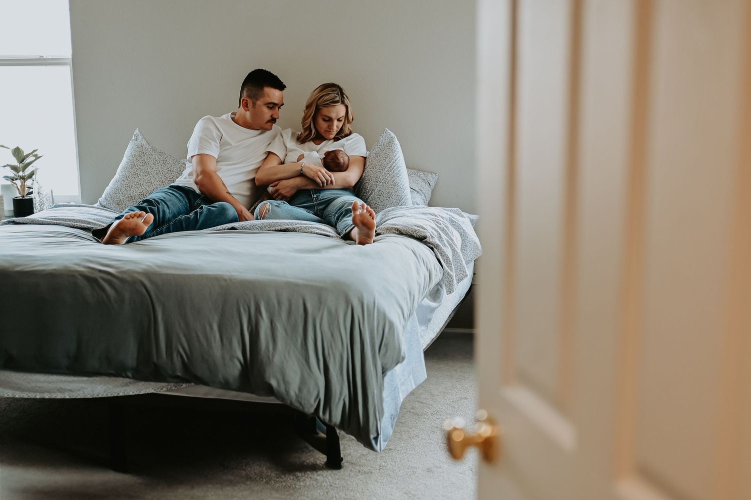 Couple relaxing together in bed while using digital devices and enjoying a lazy morning.