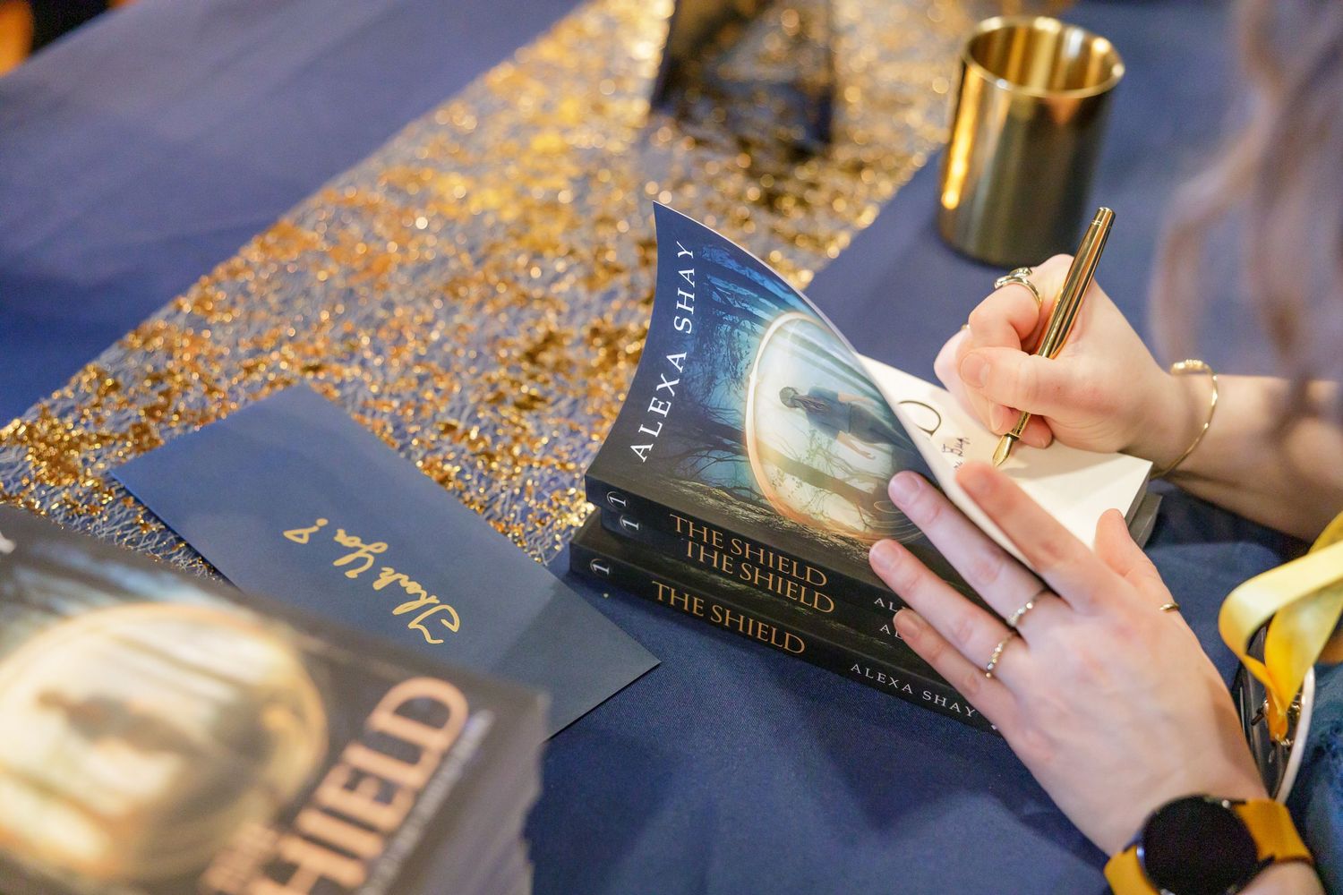 indie book author Alexa Shay author signing event in Seattle, WA woman hand signing book on table at bookstore for reader