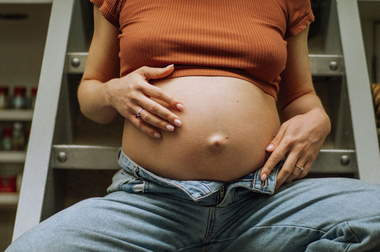 Close-up of a pregnant belly during a home maternity photoshoot.
