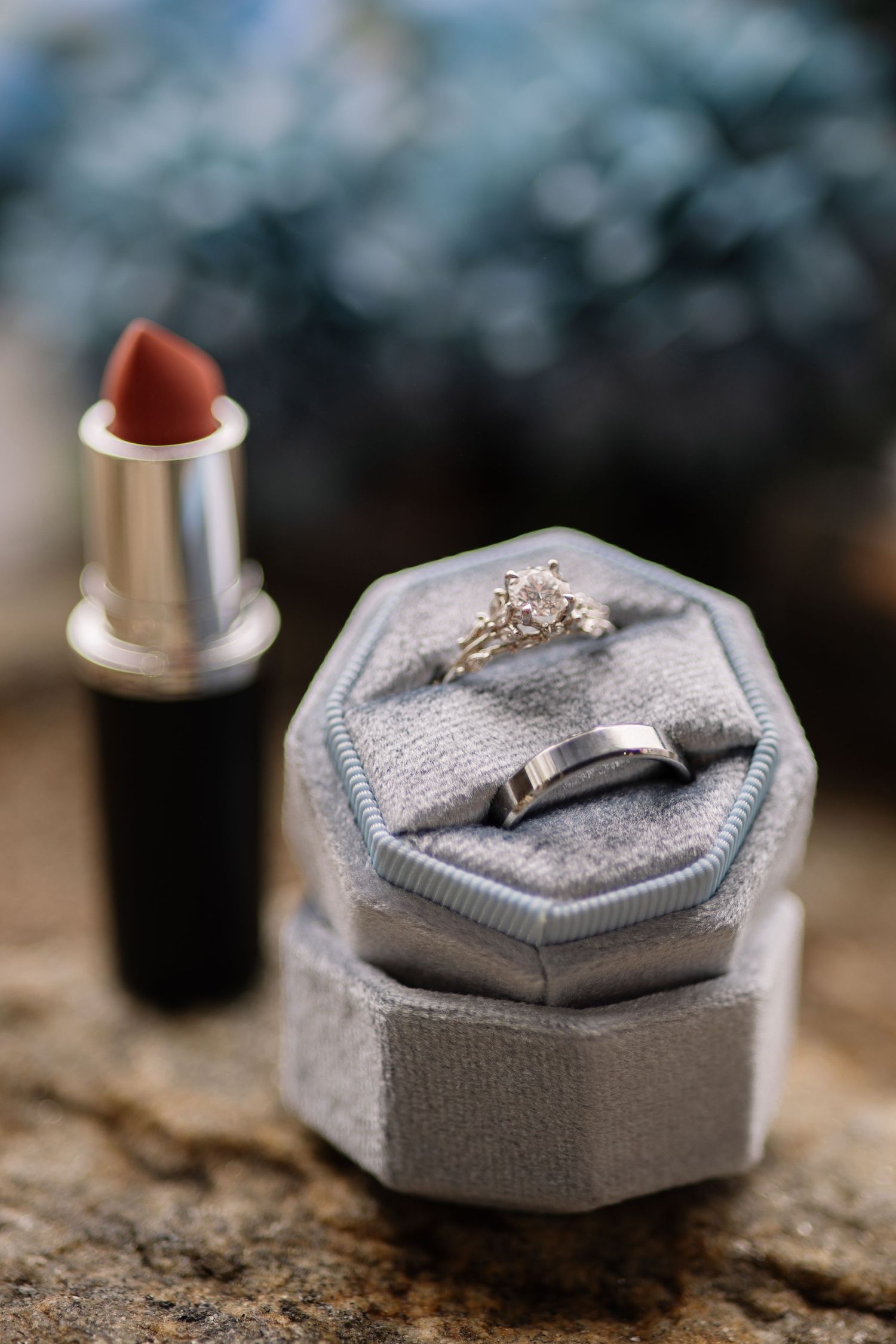 A silver engagement ring displayed on a grey hexagonal ring box shown from multiple angles.