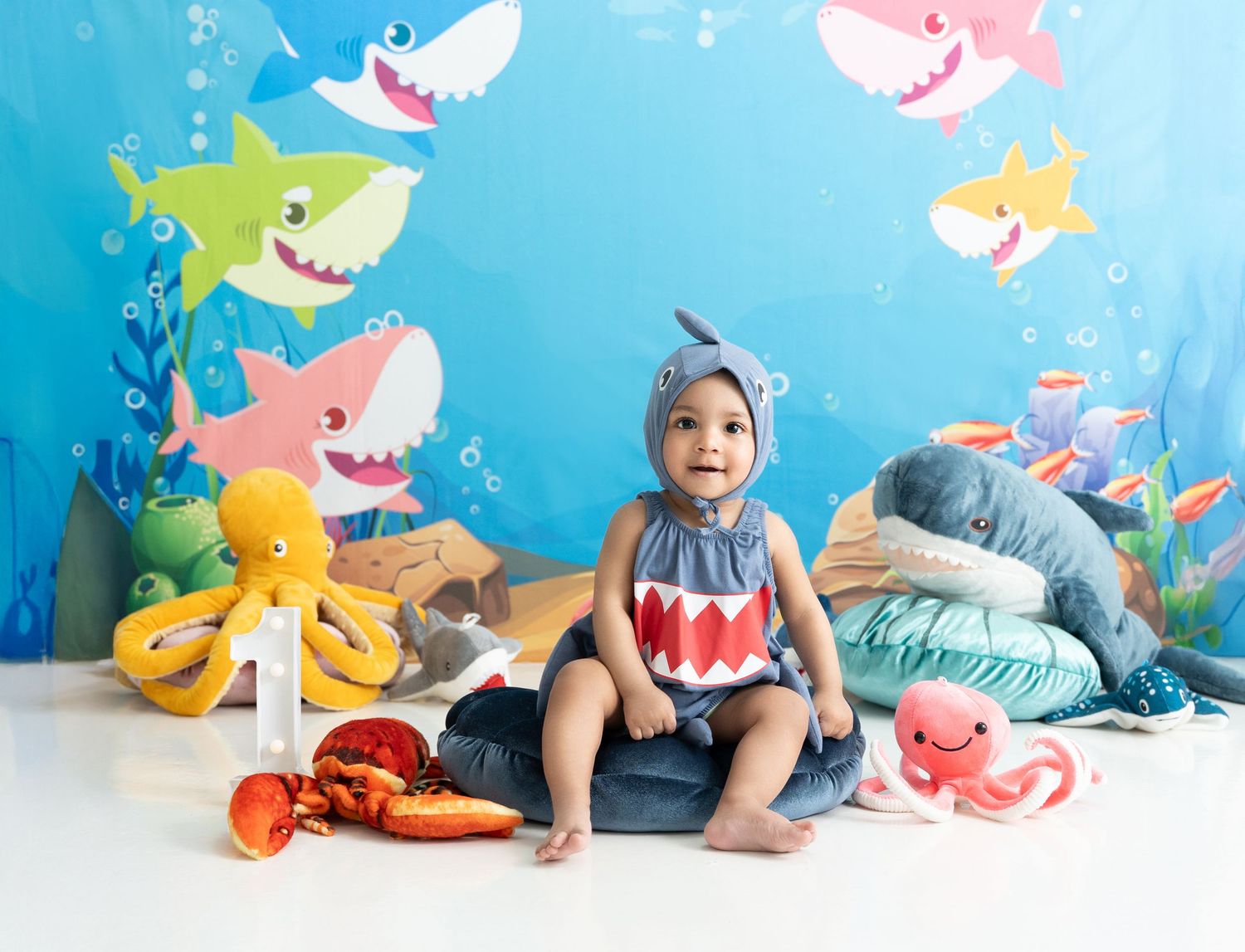 Baby enjoying a colorful first birthday cake smash in Dubai, captured by a Cake Smash Photoshoot Dubai photographer.