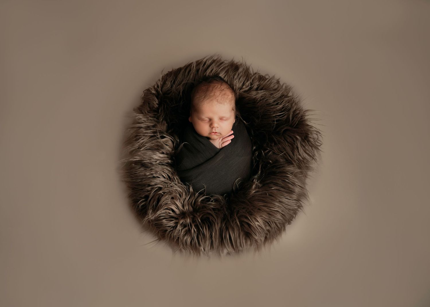 Newborn boy sleeping in furry bed during newborn session in Northbrook