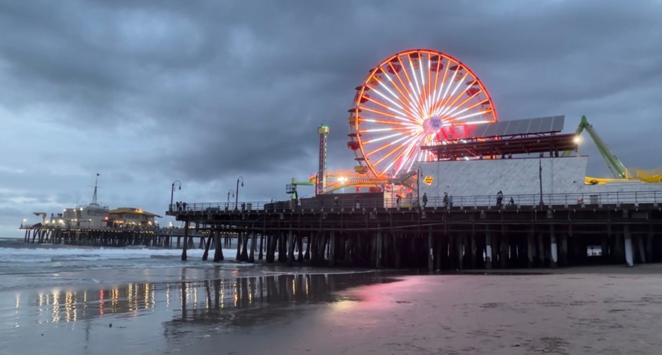 A series of photos showing a colorful illuminated ferris wheel at night reflected in calm water at Santa Monica Pier.